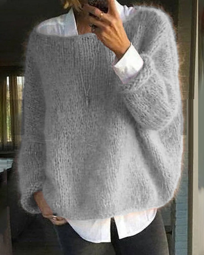 Flauschiger Pullover in Hellgrau, getragen über einer weißen Bluse