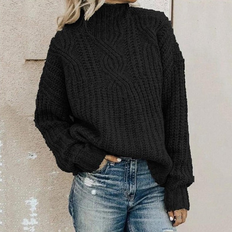 Grobstrickpullover mit Zopfmuster und Stehkragen in Schwarz, zu Jeans mit Rissen getragen