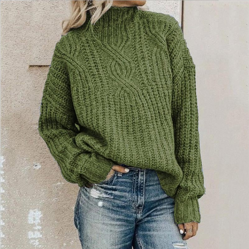 Grobstrickpullover mit Zopfmuster und Stehkragen in Olivgrün, zu Jeans mit Rissen getragen
