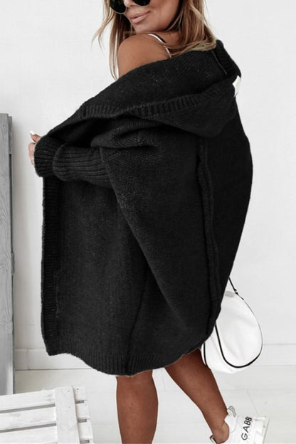 Schwarze lange Strickjacke mit Kapuze, Seitenansicht, mit weißer Tasche