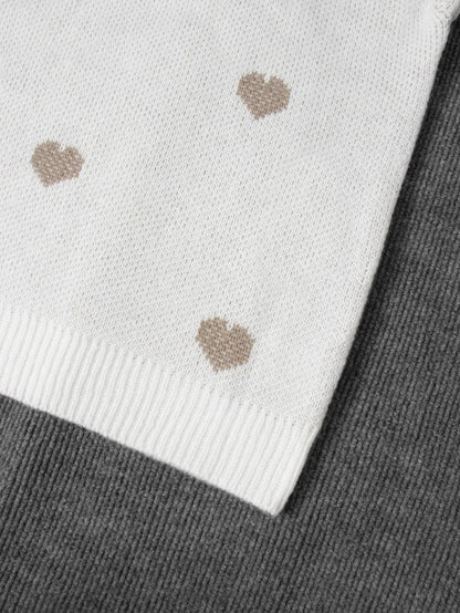 Nahaufnahme des Rippsaums am weißen Herzpullover