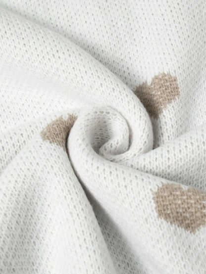 Nahaufnahme des Strickmusters mit beigefarbenen Herzen