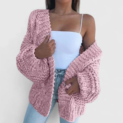 Oversize-Grobstrickjacke in Rosa, offen über einem weißen Top getragen