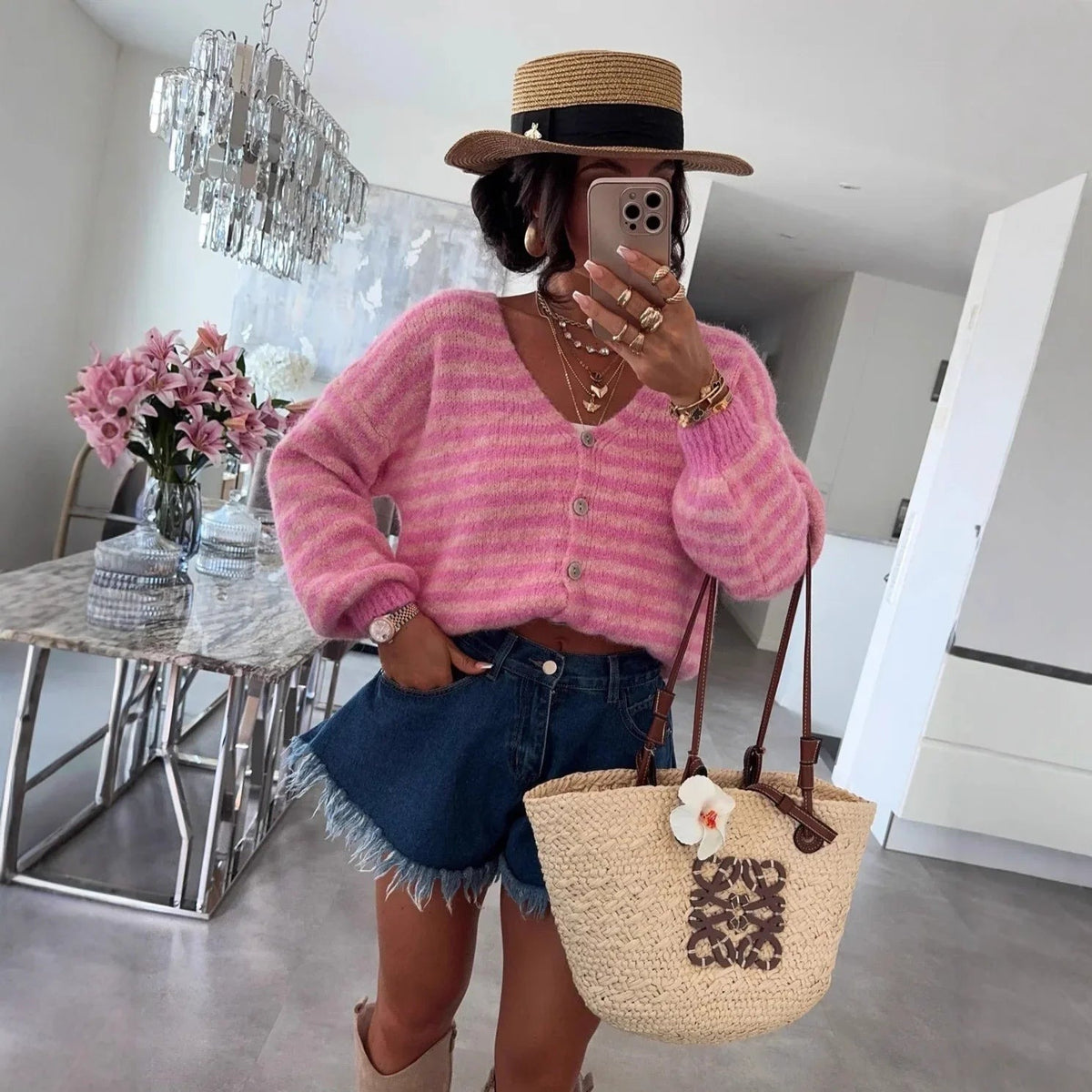 Rosa gestreifte Oversize-Strickjacke mit Jeansshorts und Strohtasche