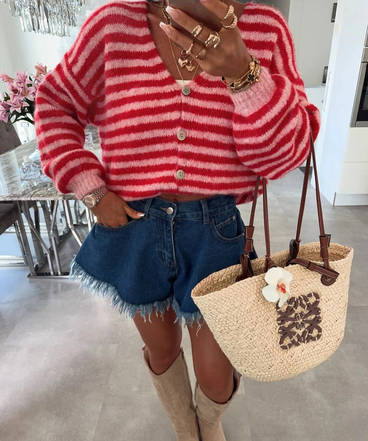 Rot-rosa gestreifte Oversize-Strickjacke zu Jeansshorts getragen