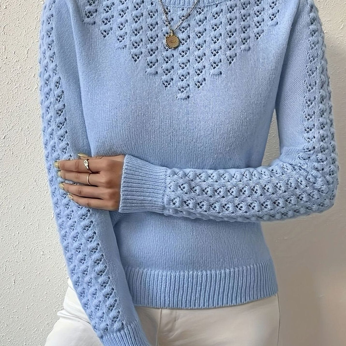 Hellblauer Strickpullover mit Ajourmuster, Nahaufnahme von Brust und Ärmel