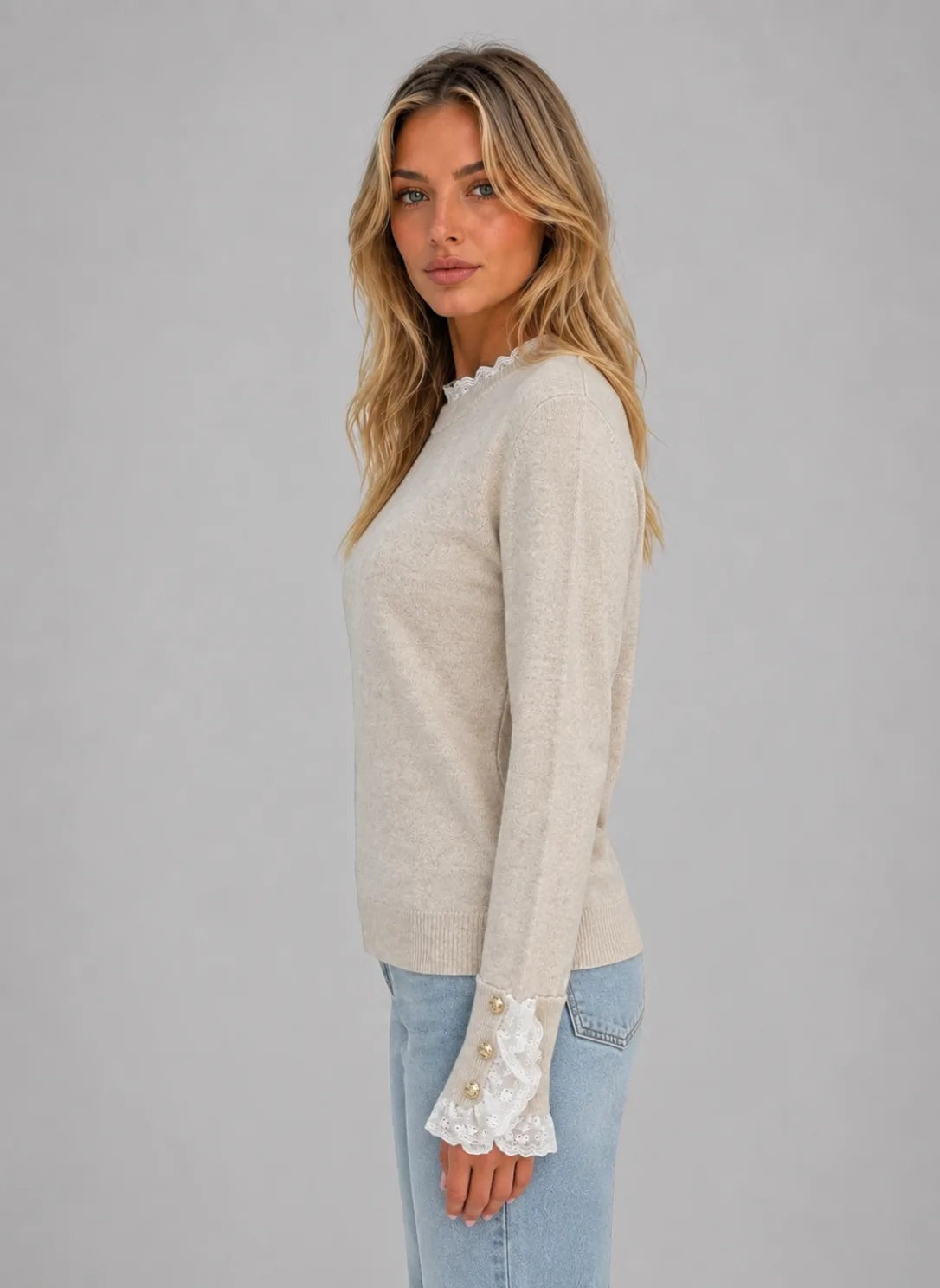 Seitenansicht des beigen Pullovers mit Spitzenbesatz und Zierknöpfen