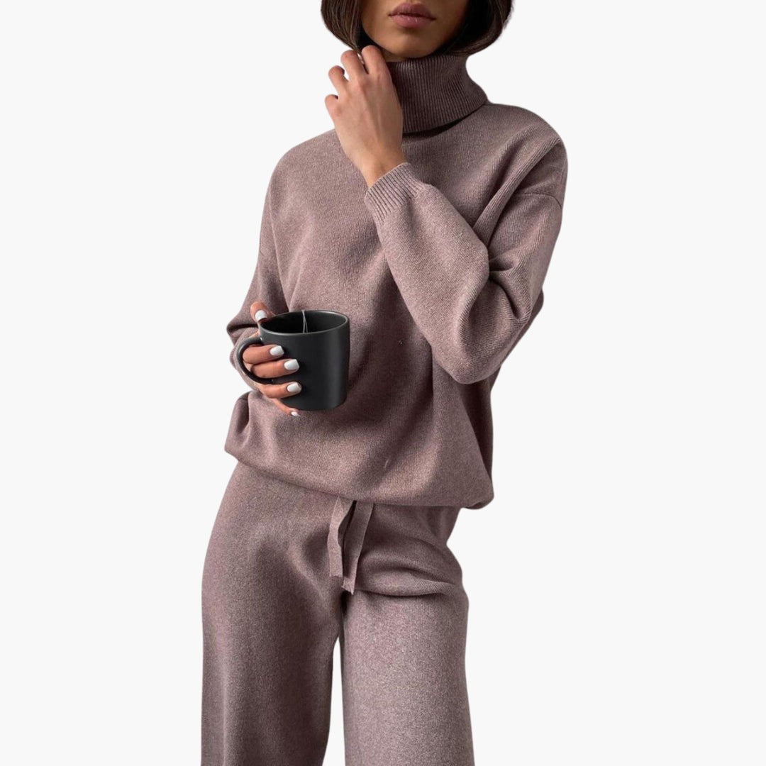 Strick-Zweiteiler für Damen in Taupe mit Rollkragen und weiter Hose, mit einer Tasse in der Hand